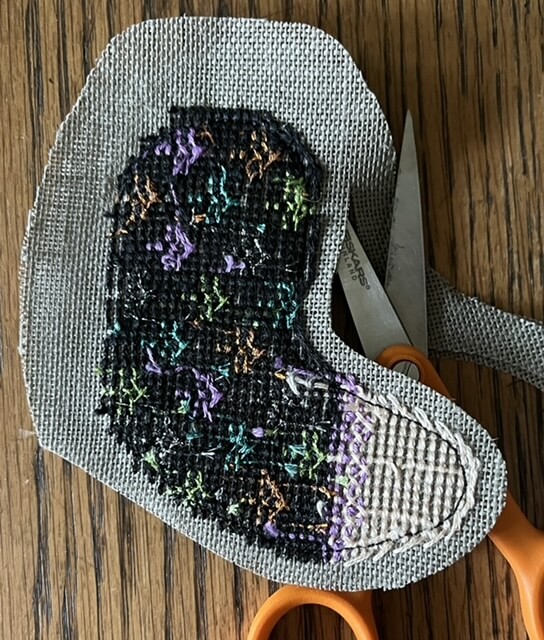 Doll arm being cut out with scissors, leaving a 1/8 inch margin.